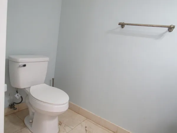 a white toilet sitting next to a shower