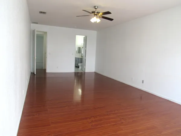 a view of empty room with wooden floor