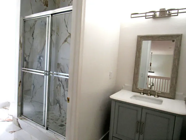 a bathroom with a shower sink and mirror