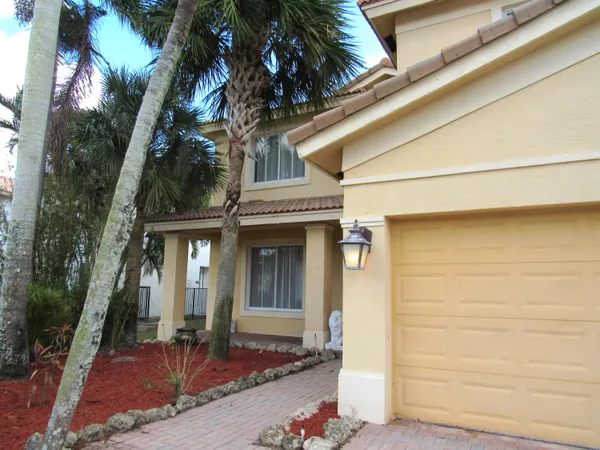 a front view of a house with a tree