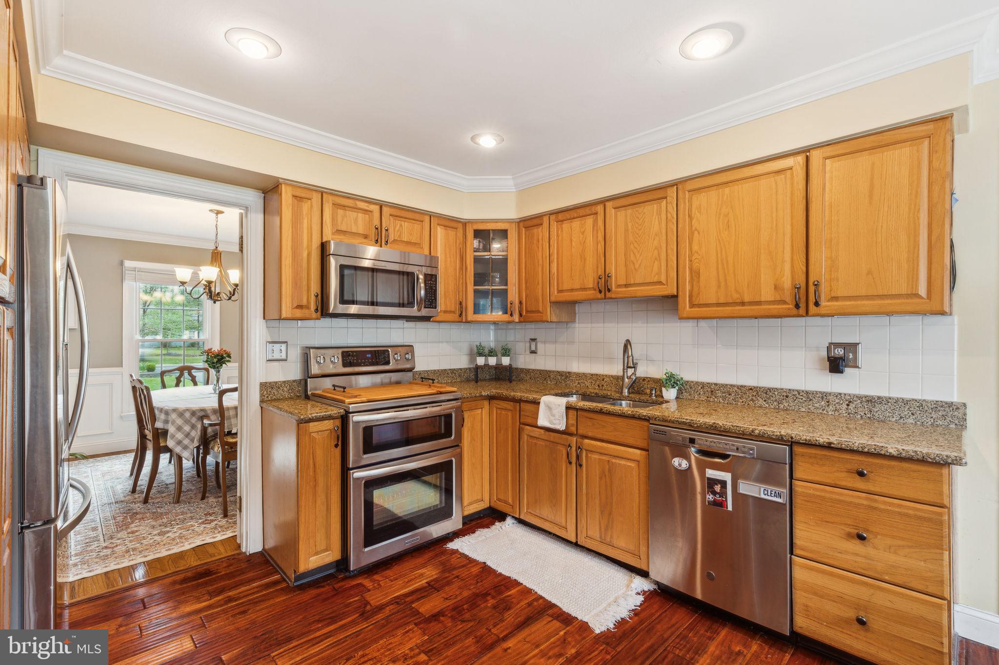25 Wallingford Way Shamong, NJ 08088 - Photo 19 of 65 a kitchen with granite countertop wooden cabinets stainless steel appliances a sink and a window