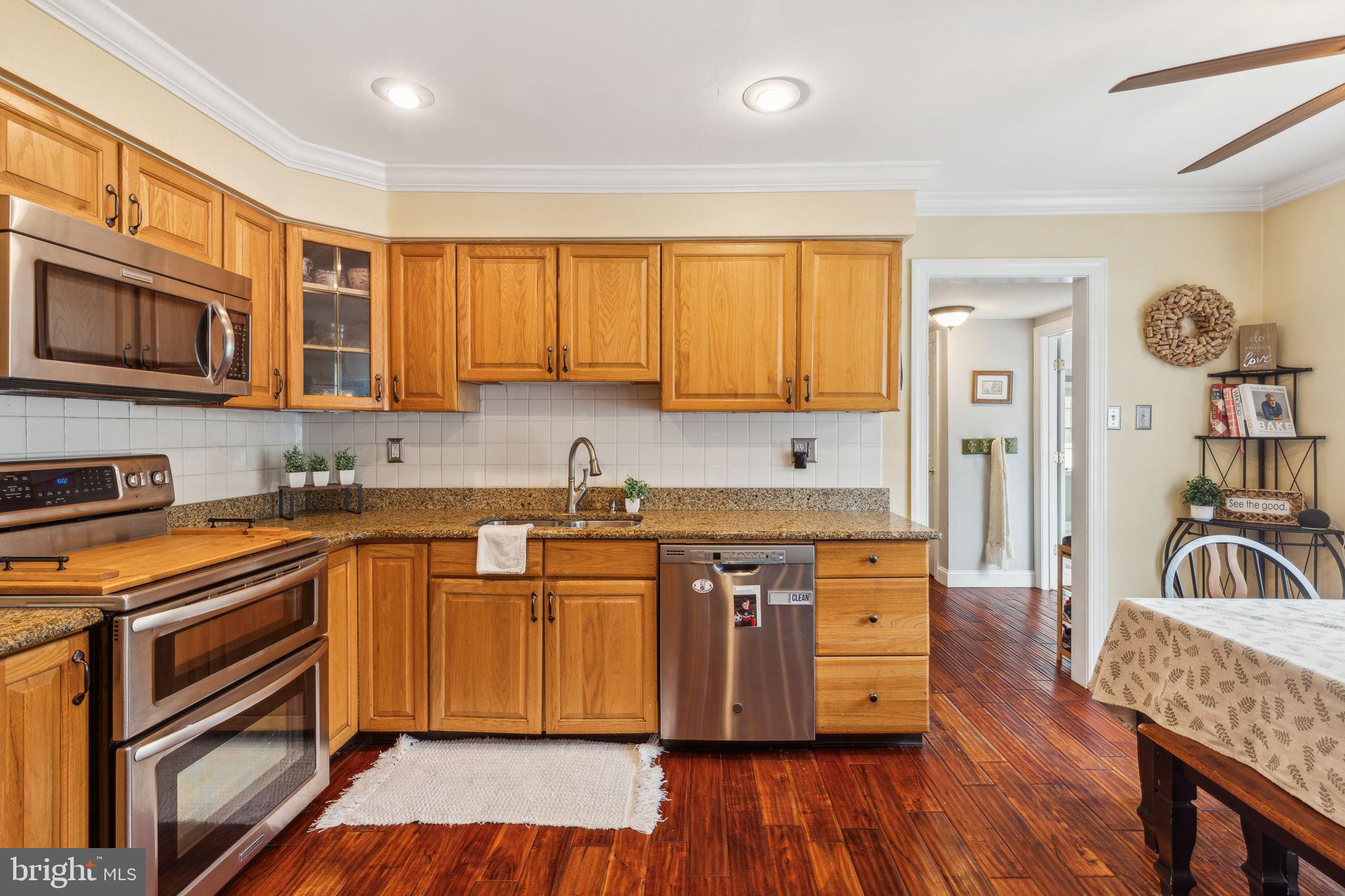 25 Wallingford Way Shamong, NJ 08088 - Photo 20 of 65 a kitchen with stainless steel appliances granite countertop wooden floor sink stove and wooden cabinets