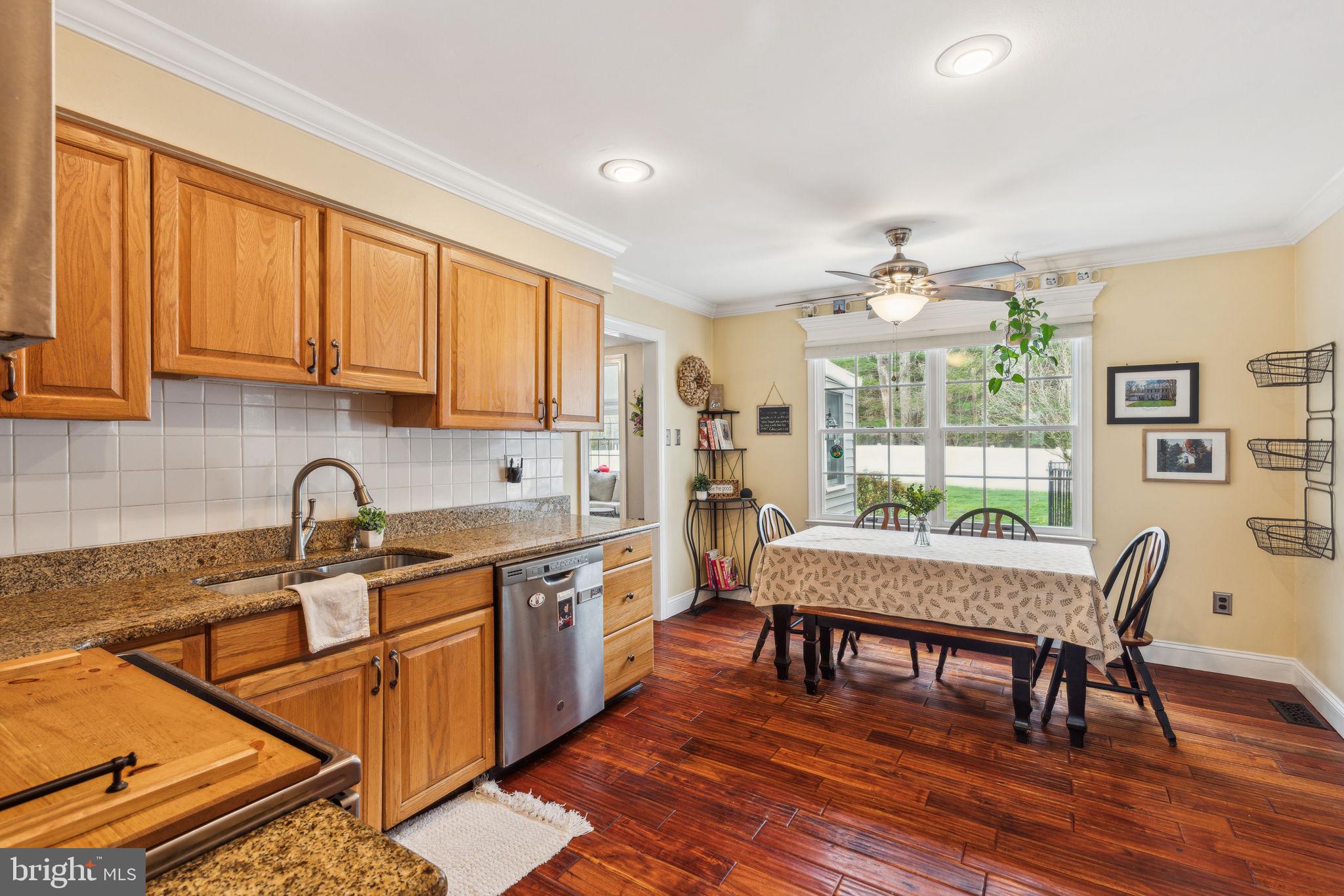 25 Wallingford Way Shamong, NJ 08088 - Photo 21 of 65 a kitchen with stainless steel appliances granite countertop a stove top oven a sink dishwasher a dining table and chairs with wooden floor