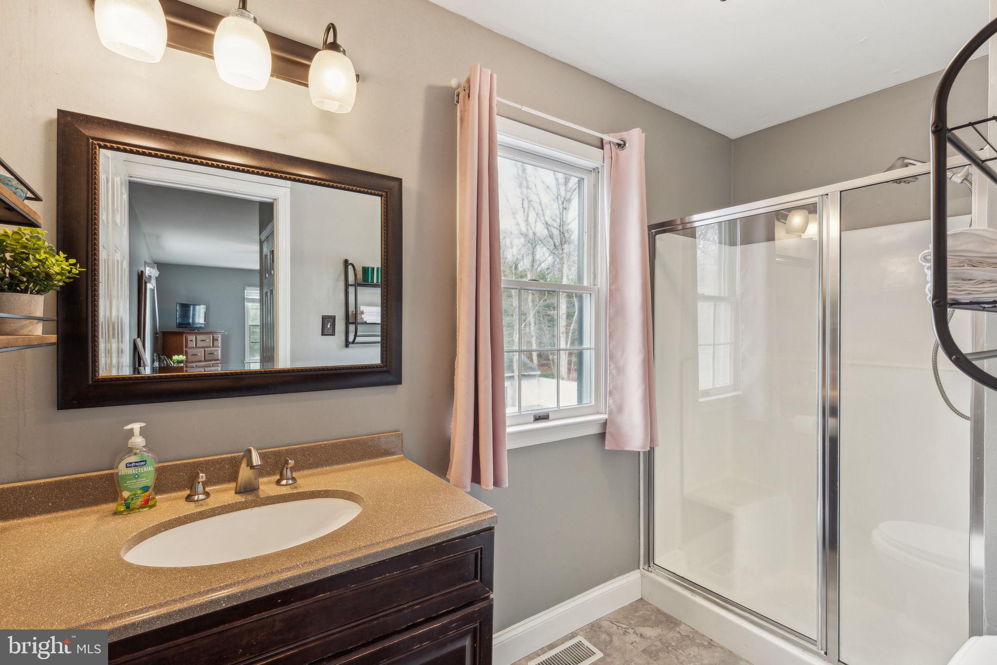 25 Wallingford Way Shamong, NJ 08088 - Photo 47 of 65 a bathroom with a granite countertop sink a mirror a vanity and a shower