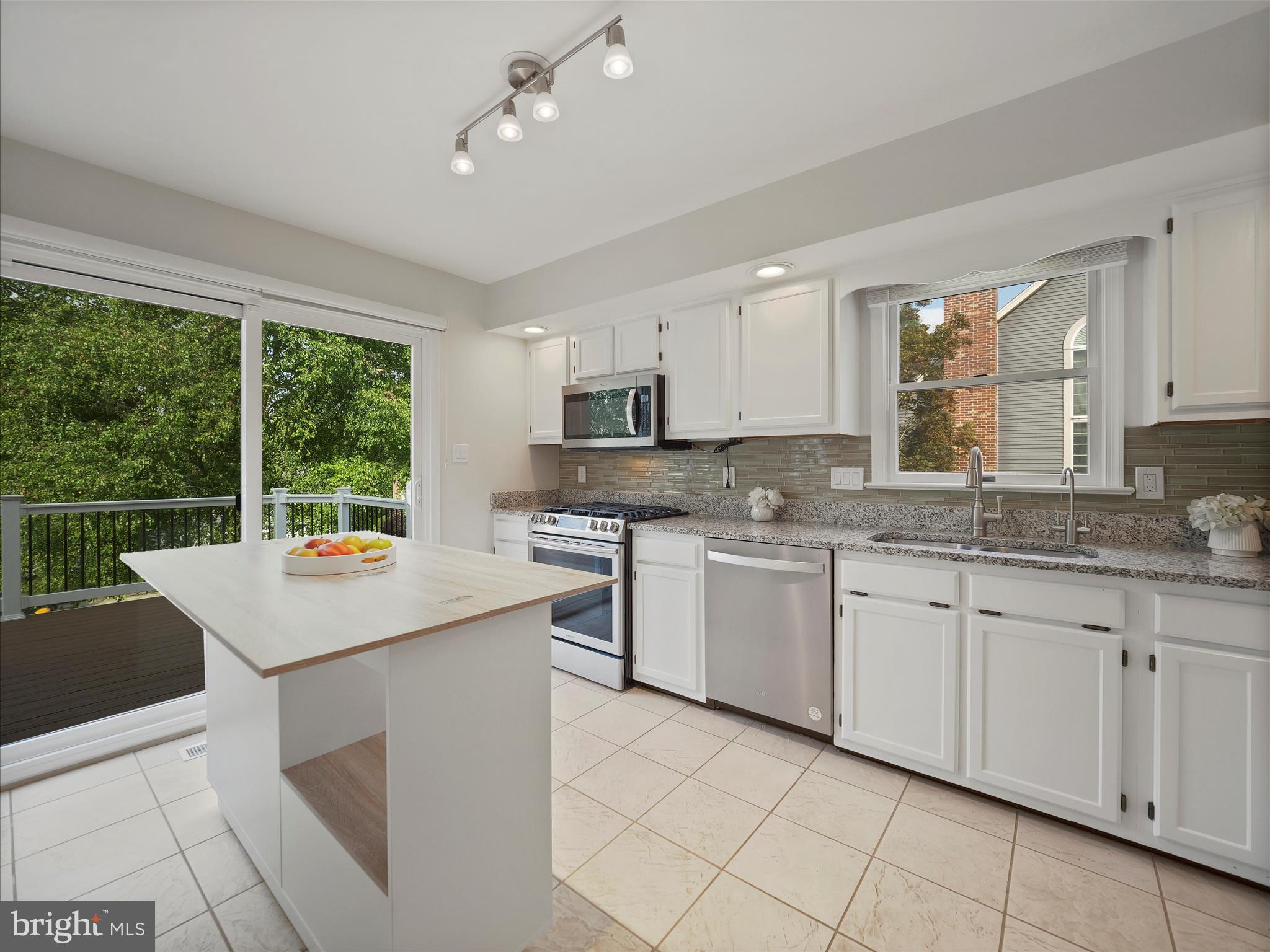 4614 Newington Road Jefferson, MD 21755 - Photo 6 of 35 a kitchen with granite countertop white cabinets white appliances a sink and a large window