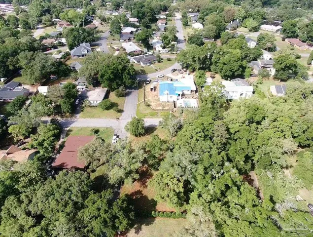 an aerial view of residential house with outdoor space and trees all around