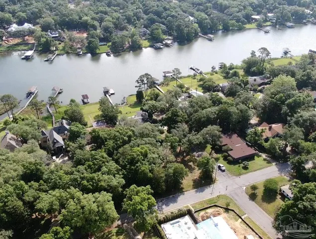 an aerial view of residential house with outdoor space and trees all around
