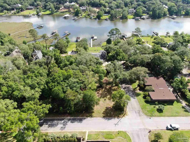 an aerial view of a house with a yard and lake view