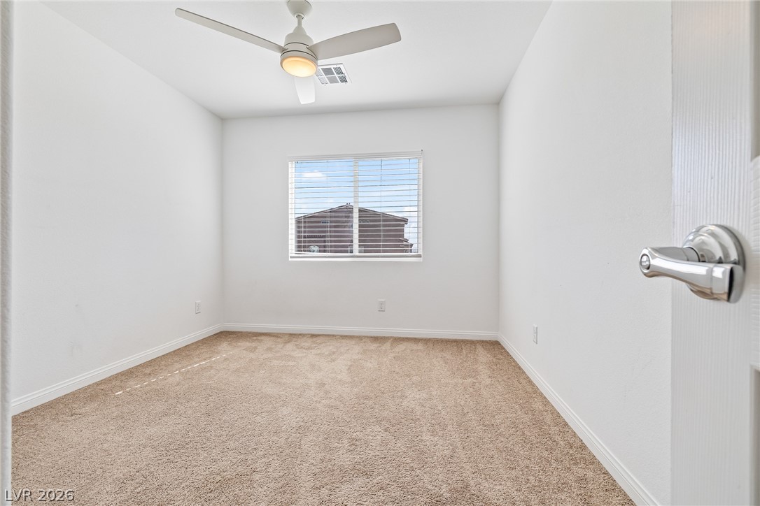 5510 Ripple Ridge Avenue Las Vegas, NV 89139 - Photo 32 of 45 This bright bedroom features a ceiling fan, carpet flooring, and a window with blinds, creating a comfortable living space.