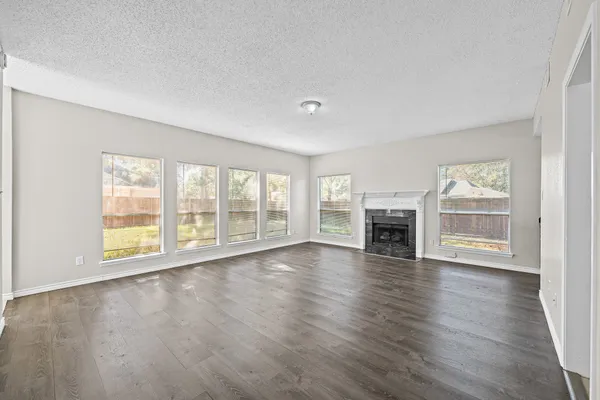 a view of empty room with wooden floor and fireplace