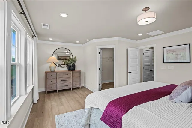 a bedroom with a bed and wooden floor