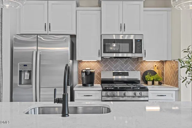 a kitchen with stainless steel appliances granite countertop a refrigerator and a stove top oven