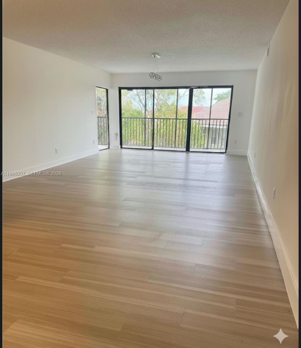 605 Ives Dairy Road, Unit 3067 Miami, FL 33179 - Photo 2 of 28 a view of empty room with wooden floor and fan