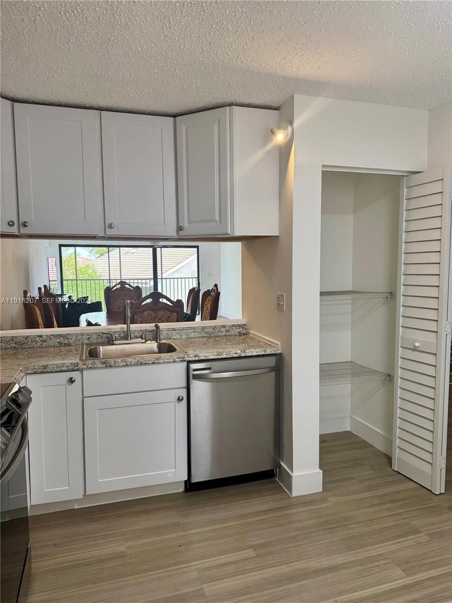 605 Ives Dairy Road, Unit 3067 Miami, FL 33179 - Photo 5 of 28 a kitchen with a sink cabinets and wooden floor