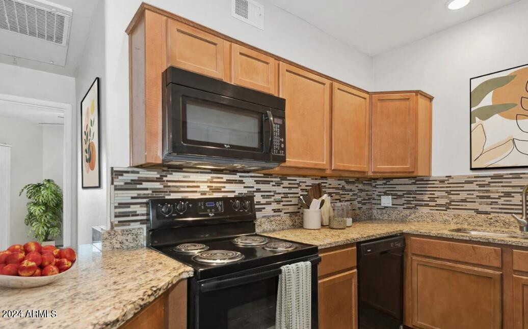 9259 East Raintree Drive, Unit 1 Scottsdale, AZ 85260 - Photo 4 of 15 a kitchen with stainless steel appliances granite countertop a stove a sink and a microwave
