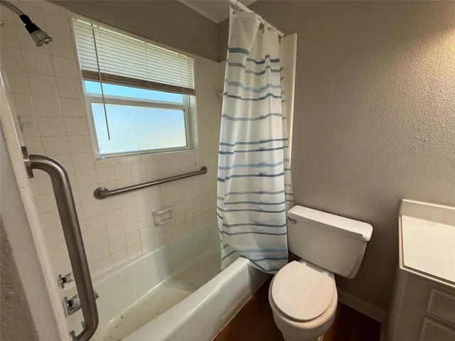 a white toilet sitting next to a bath tub