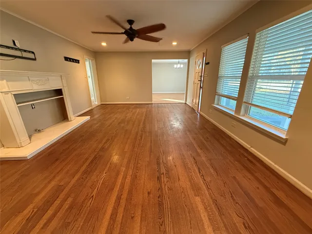a view of a livingroom with wooden floor and a ceiling fan