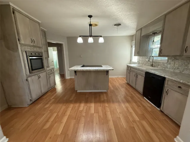 a view of a kitchen with wooden floor and electronic appliances