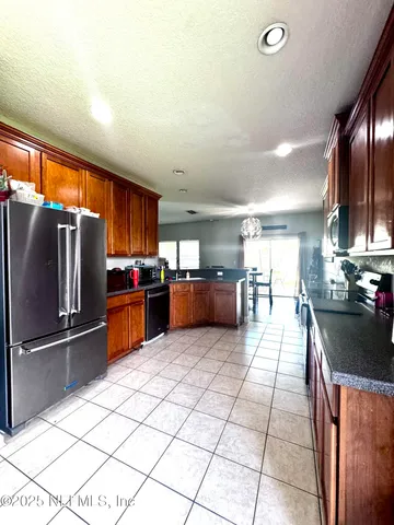 a kitchen with stainless steel appliances granite countertop a refrigerator and a sink