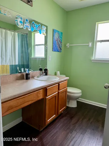 a bathroom with a sink a toilet and mirror