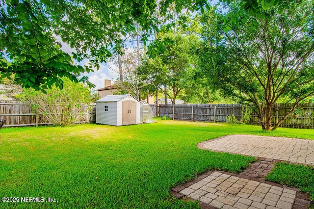 a view of a backyard with a garden and trees