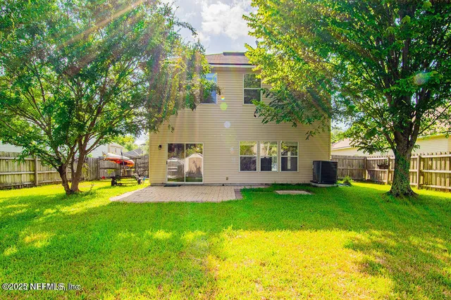 a view of a house with a big yard and large trees