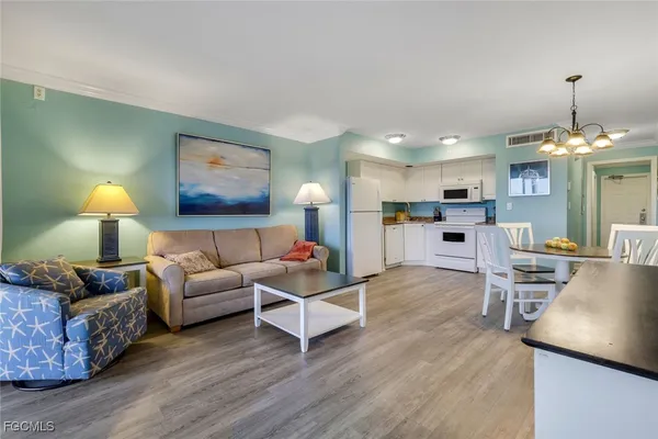 a living room with furniture and kitchen view