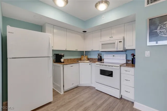 a kitchen with white cabinets and white appliances