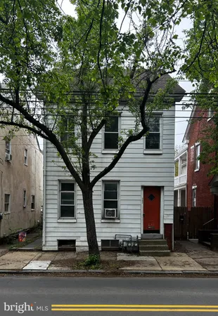 a front view of a house with a tree