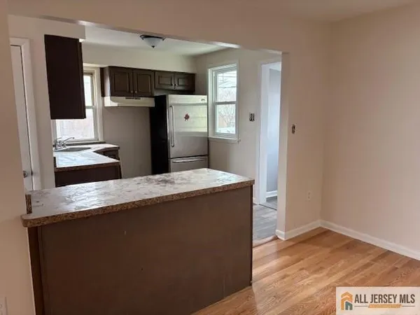 a kitchen with kitchen island a counter top space a sink and refrigerator