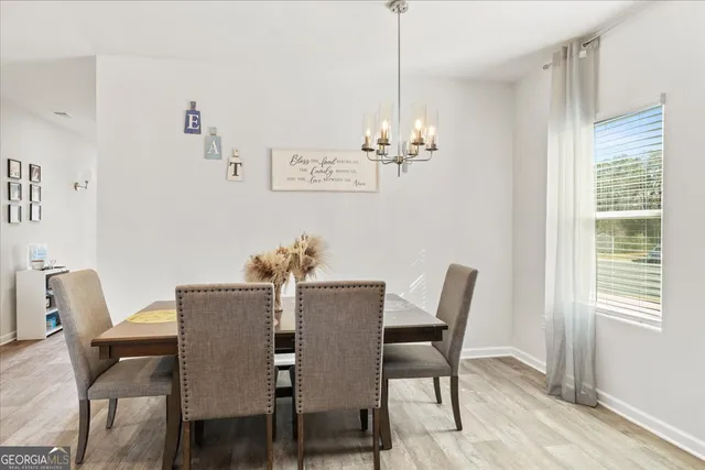 a view of a dining room with furniture wooden floor and a chandelier