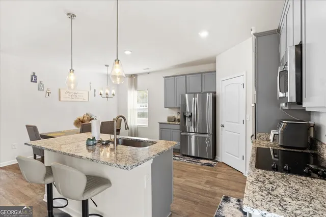 a kitchen with stainless steel appliances granite countertop a sink refrigerator and cabinets