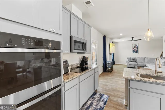 a kitchen with granite countertop a sink and cabinets