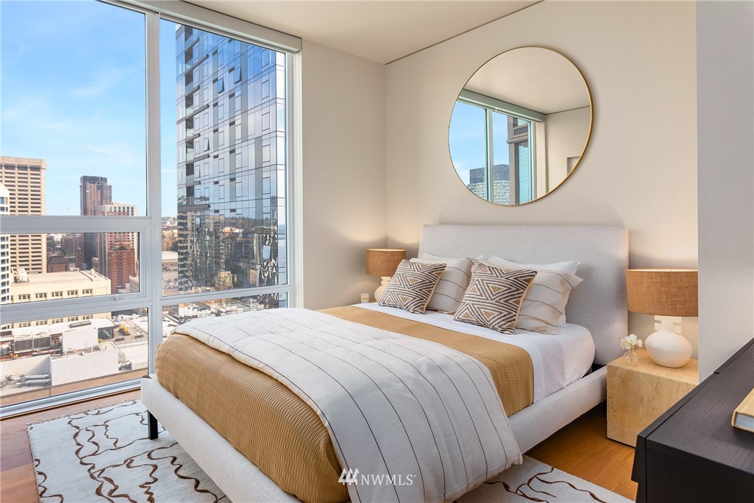 121 Stewart Street, Unit 2201 Seattle, WA 98101 - Photo 12 of 23 a spacious bedroom with bed and a mirror