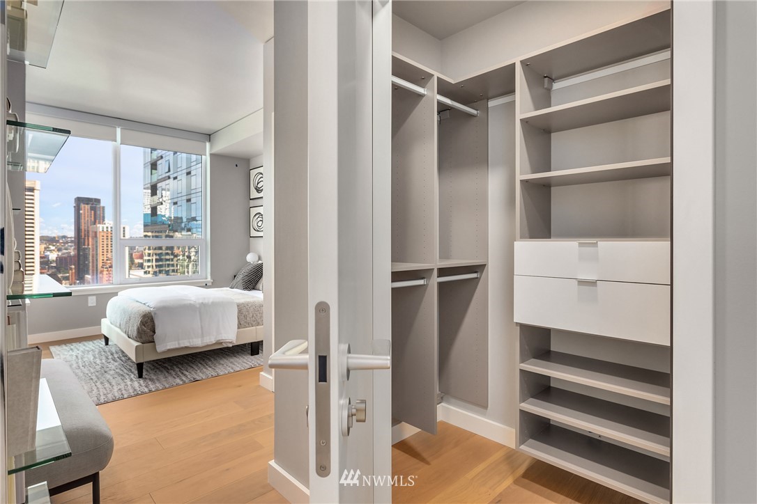 121 Stewart Street, Unit 2201 Seattle, WA 98101 - Photo 13 of 23 a bedroom with a bed and a window with chair