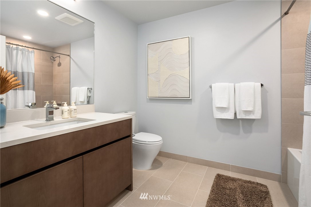 121 Stewart Street, Unit 2201 Seattle, WA 98101 - Photo 14 of 23 a bathroom with a toilet sink and mirror