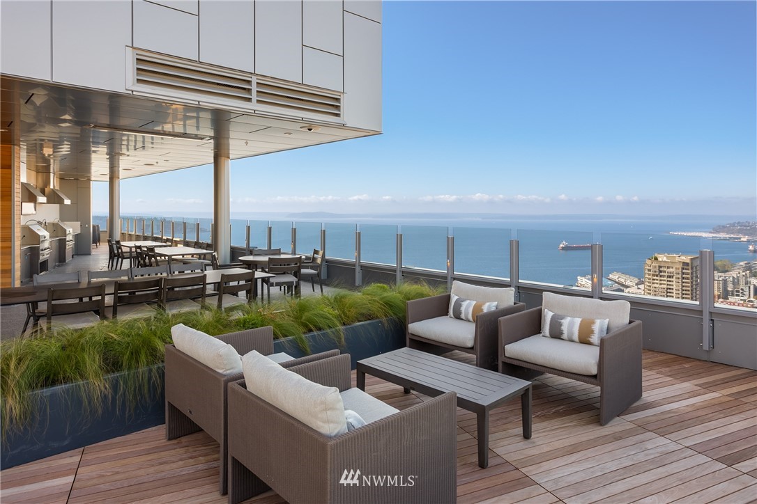 121 Stewart Street, Unit 2201 Seattle, WA 98101 - Photo 18 of 23 a roof deck with couches and potted plants with wooden floor