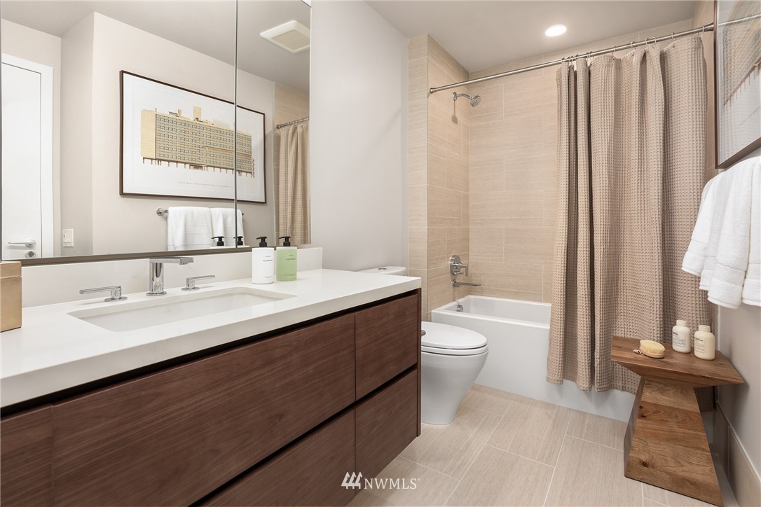121 Stewart Street, Unit 2201 Seattle, WA 98101 - Photo 4 of 23 a bathroom with a double vanity sink toilet mirror and bathtub