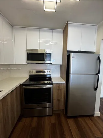 a kitchen with a refrigerator and a stove