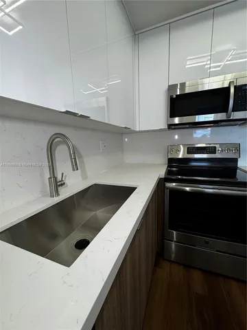 a kitchen with a sink stove and microwave