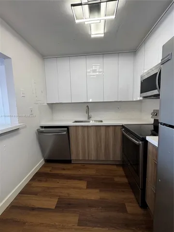 a kitchen with granite countertop a stove and cabinets