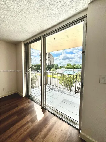 a view of a room with wooden floor and a floor to ceiling window