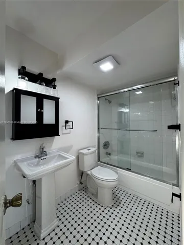 a bathroom with a sink toilet a mirror and shower