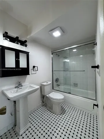 a bathroom with a sink toilet a mirror and shower