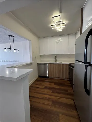 a kitchen with kitchen island a counter top space appliances and cabinets