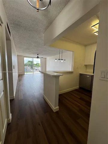 a kitchen with a sink and wooden floors