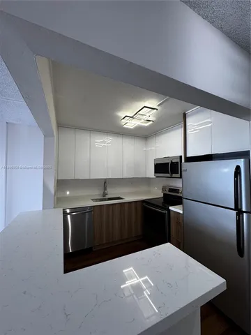 a kitchen with stainless steel appliances a refrigerator a sink a stove a microwave and island