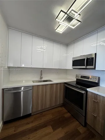 a kitchen with stainless steel appliances a stove a microwave and sink