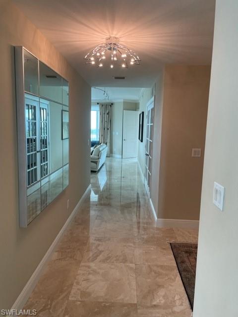 265 Indies Way, Unit 701 Naples, FL 34110 - Photo 13 of 36 a view of a hallway with windows and chandelier