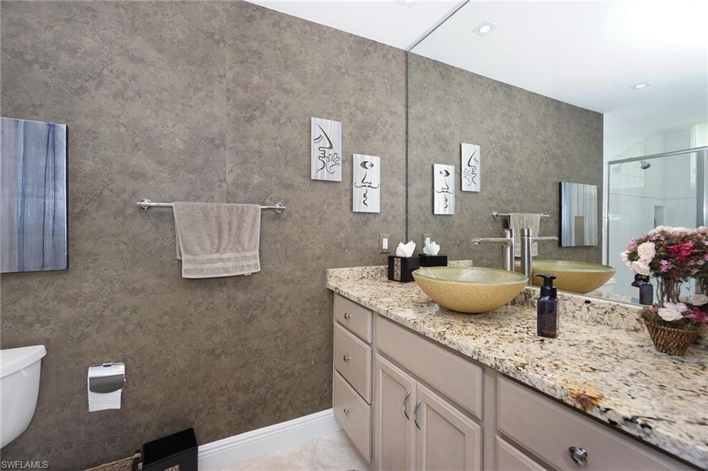 265 Indies Way, Unit 701 Naples, FL 34110 - Photo 21 of 36 a bathroom with sink and mirror